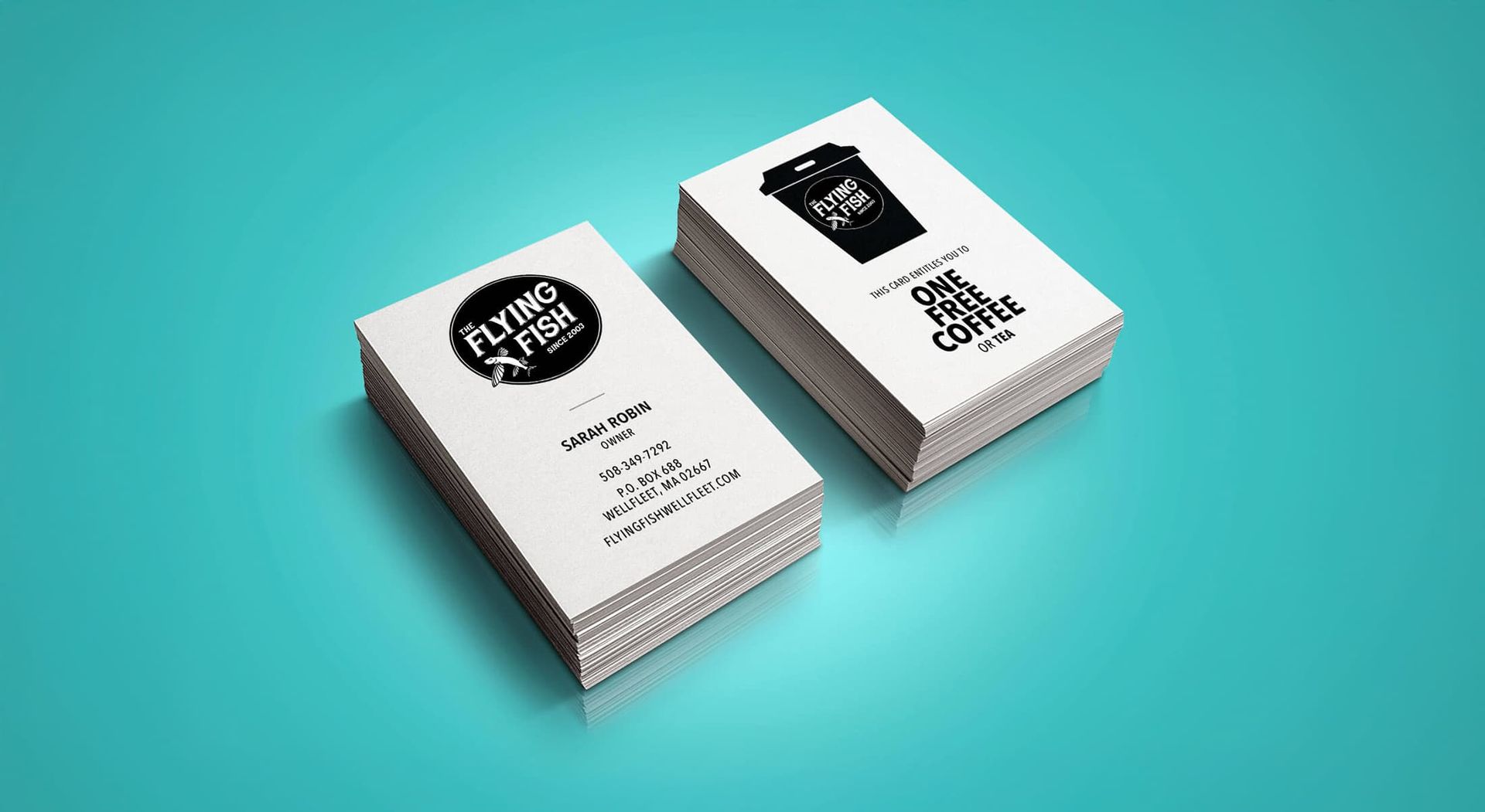Two stacks of business cards with black logos on a light background; teal surface.