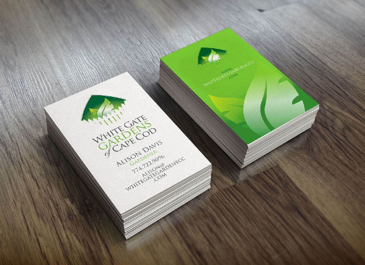 Two stacks of White Gate Garden & Cafe Duo business cards on a wood surface. Green and white color scheme.