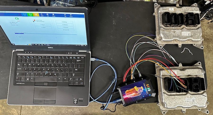 A laptop is sitting on a table next to a bunch of wires.
