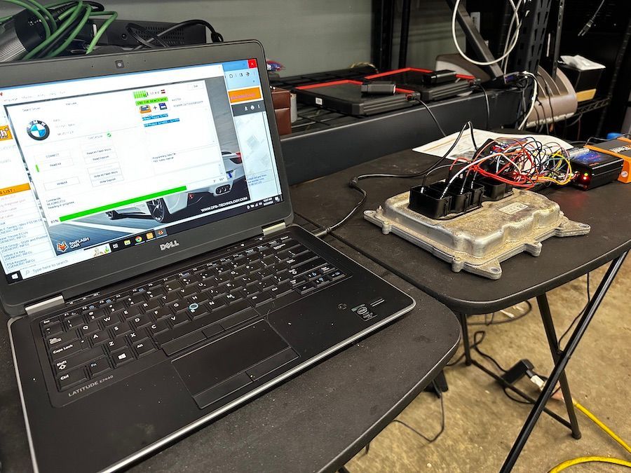 A laptop computer is sitting on top of a table next to a computer chip.