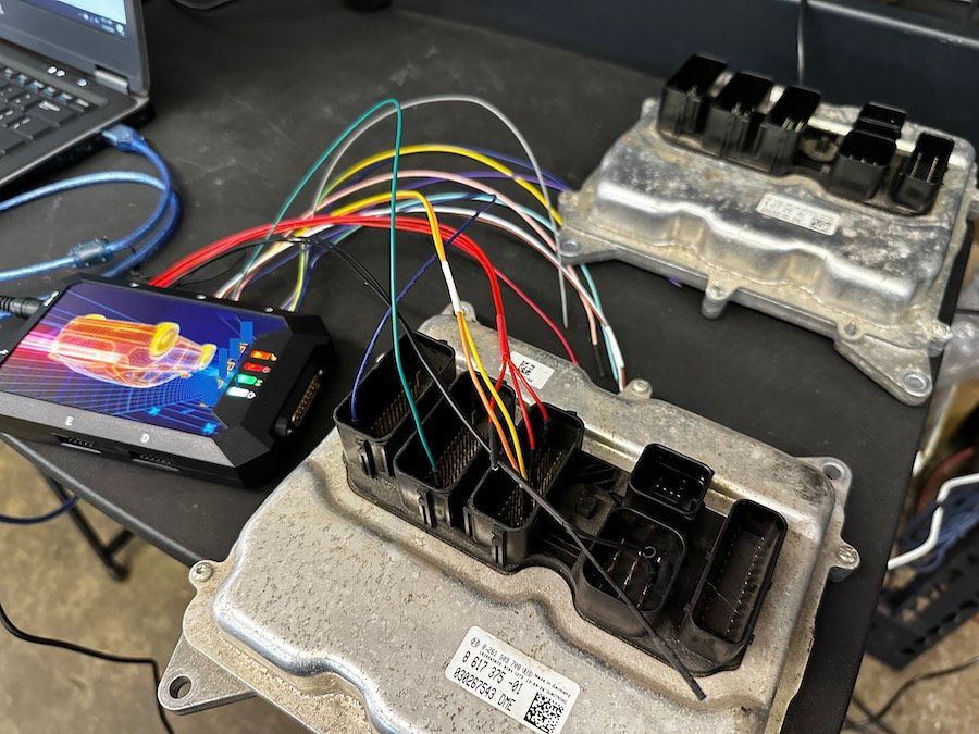 A bunch of wires are connected to a computer on a table.