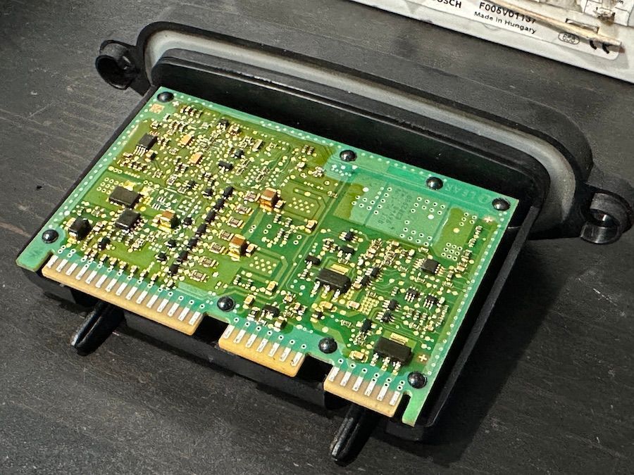 A green motherboard is sitting on a black surface