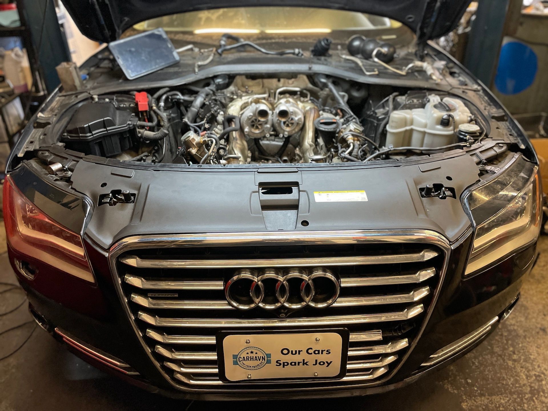 The hood of an audi is open and the engine is visible