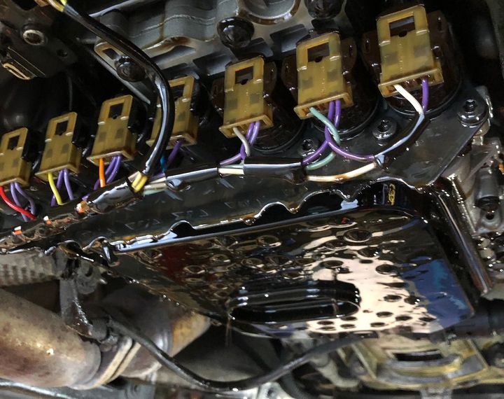 A close up of a car engine with a lot of wires coming out of it