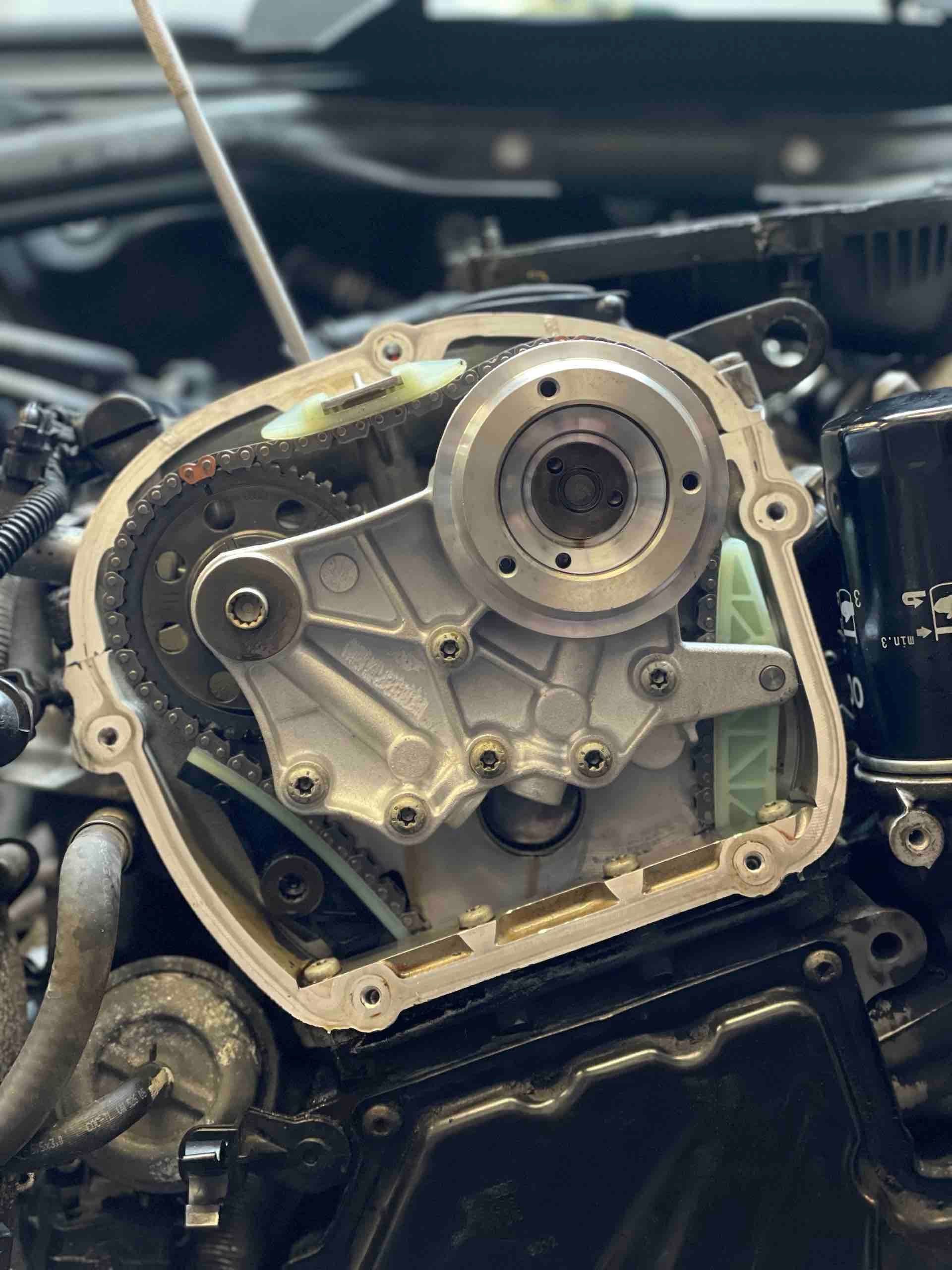 A close up of a car engine with a screwdriver in it.