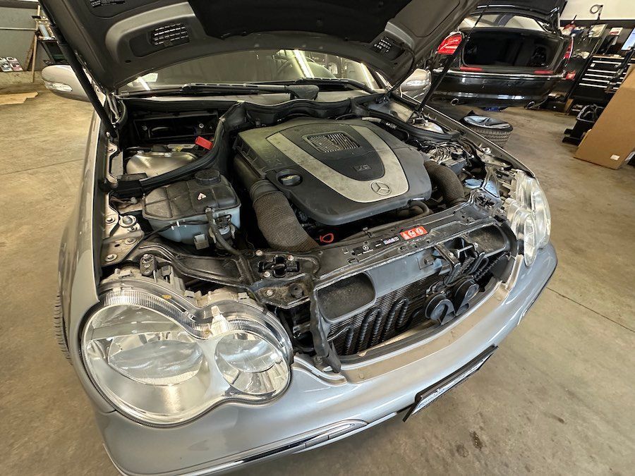 The hood of a car is open and the engine is visible.