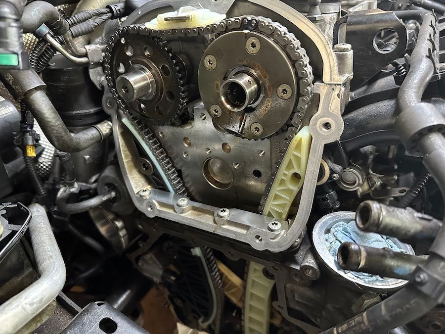 A close up of a car engine with the timing chain removed.