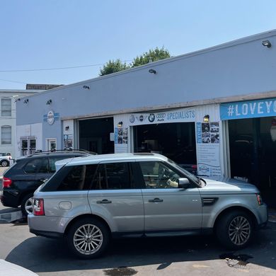 A silver range rover is parked in front of a garage