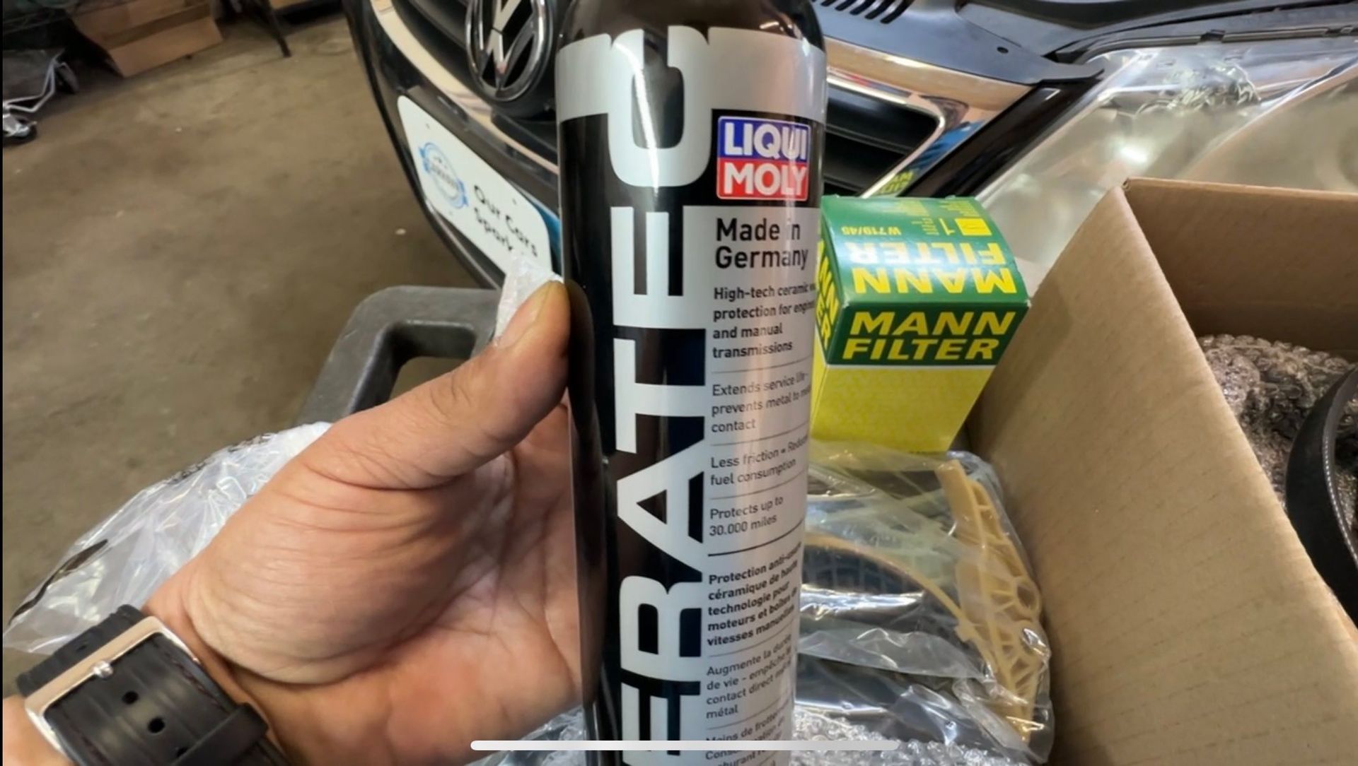 A person is holding a bottle of liqui moly fratec