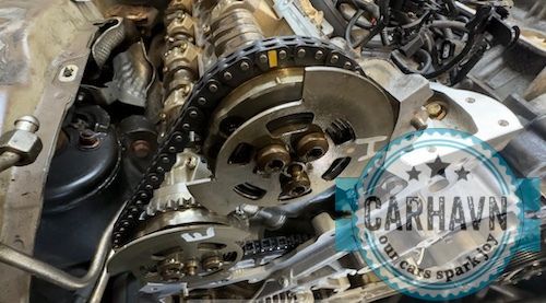 A close up of a chain on a car engine.