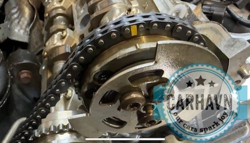 A close up of a chain on a car engine.