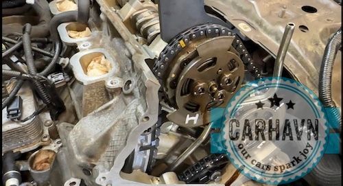 A close up of a car engine with a chain on it.