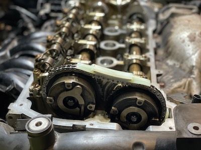 A close up of a car engine with a green tape on it.