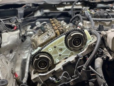 A close up of a car engine with a chain on it.
