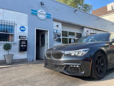 A bmw is parked in front of a garage.
