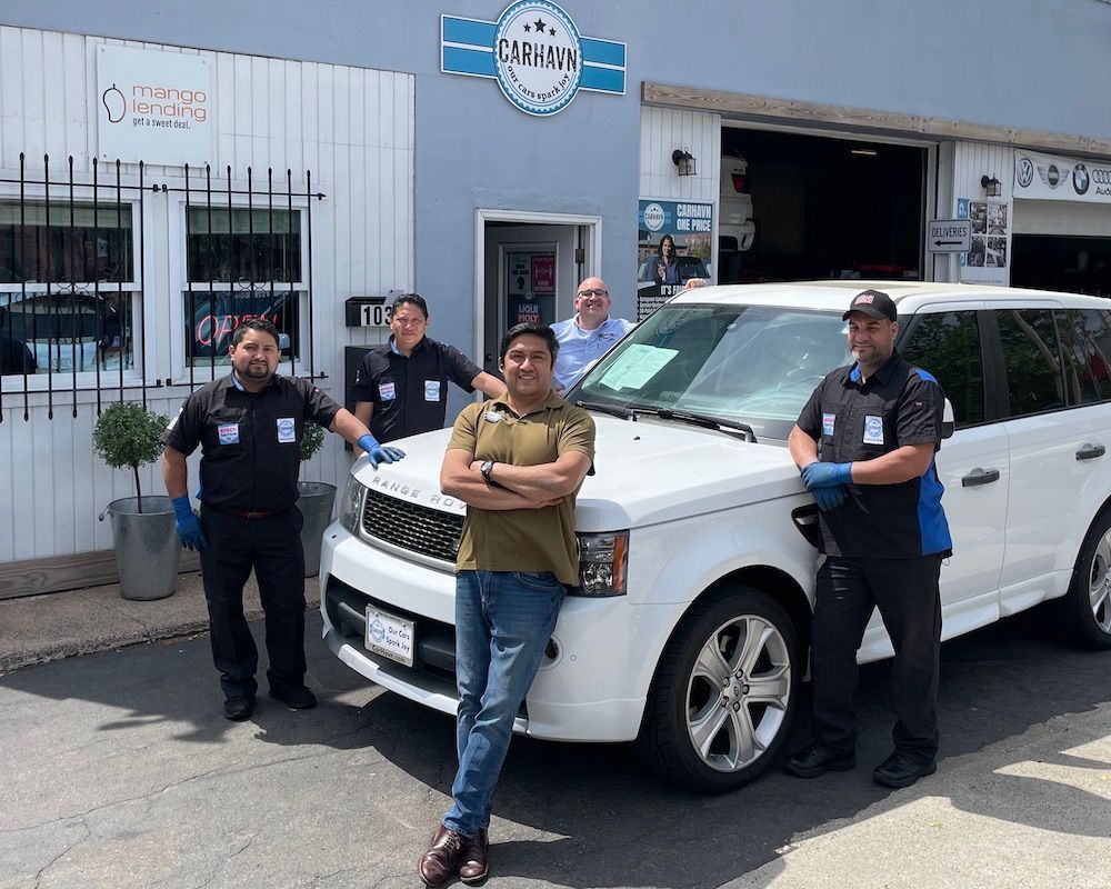 A group of men are standing in front of a white suv.