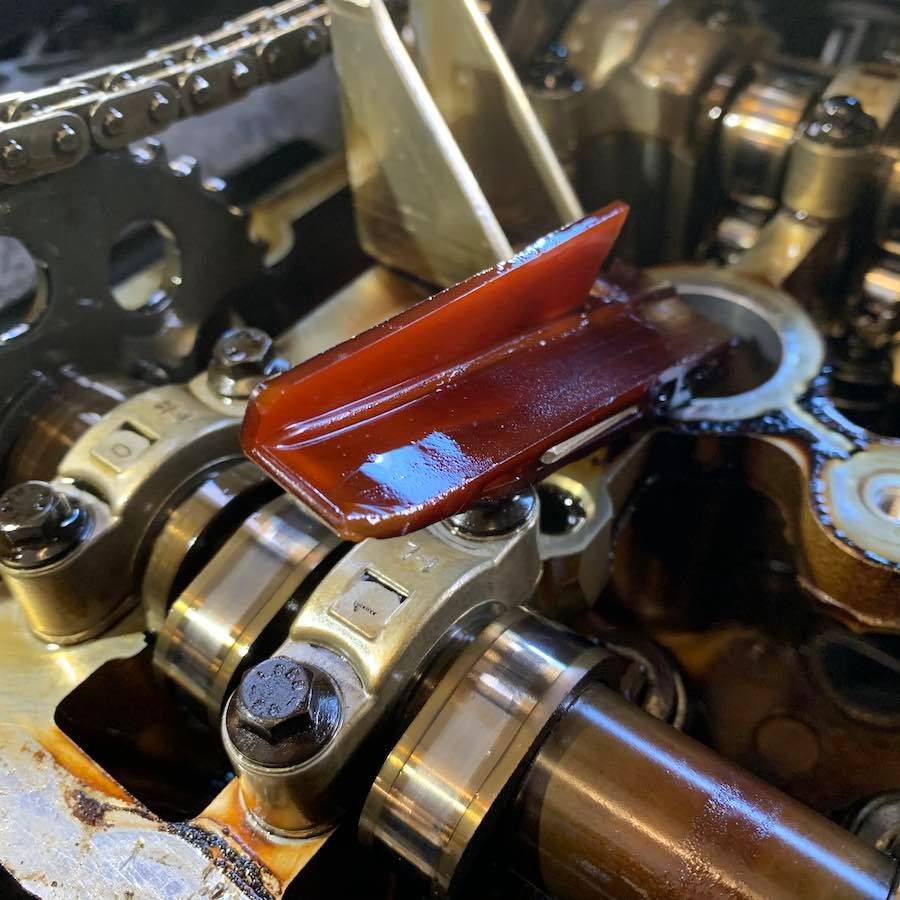 A close up of a car engine with a red piece of metal on it
