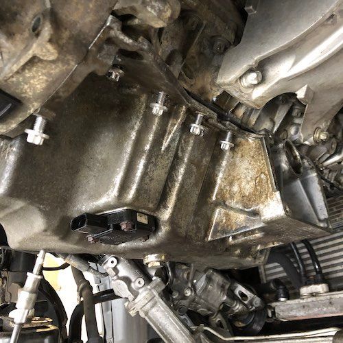 A close up of the underside of a car engine.
