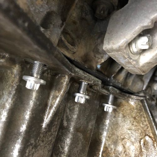 A close up of a metal object with screws on it.