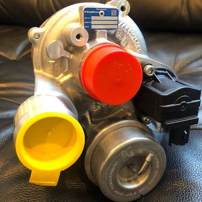A turbocharger is sitting on a black leather couch.