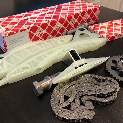 A bunch of parts on a table including a chain