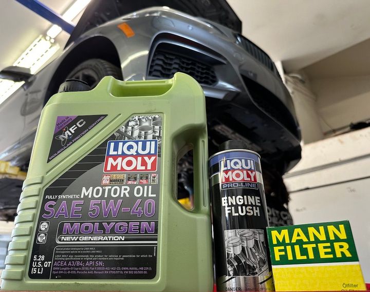 A bottle of liqui moly motor oil next to a mann filter