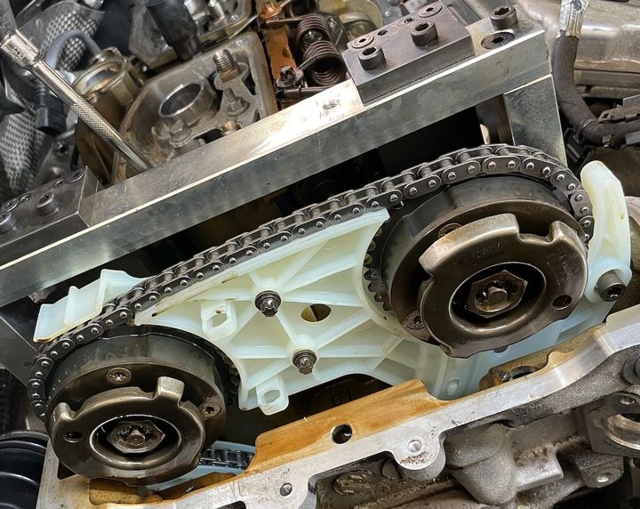 A close up of a chain on a car engine.
