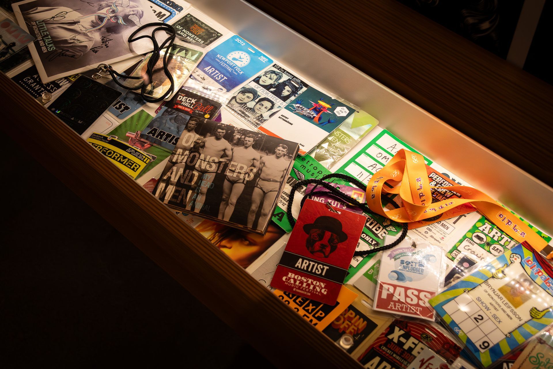 Display case featuring of Monsters and men related memorabilia, backstage passes, badges, CDs, and music items.