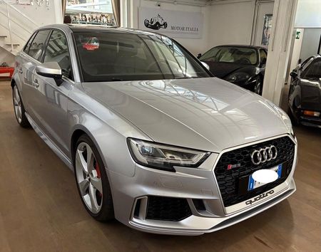 Berlina Audi color argento parcheggiata all'interno di uno showroom, vista anteriore sinistra.