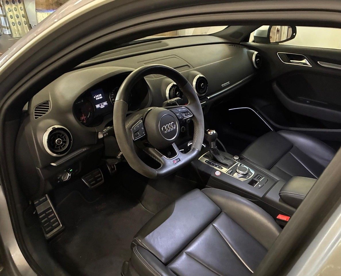Interni di lusso dell'auto con sedili in pelle nera, volante, cruscotto e console centrale visibili