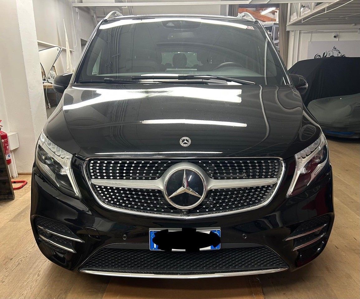 Vista frontale di un furgone Mercedes-Benz Classe V nero parcheggiato in un garage coperto ben illuminato.