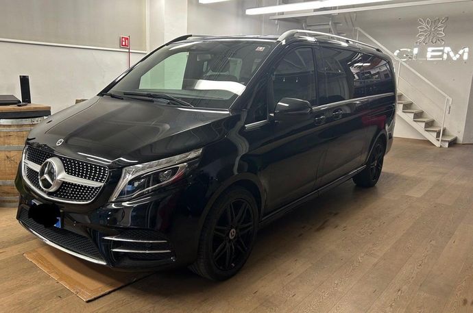 Un minivan Mercedes-Benz Classe V nero parcheggiato all'interno di un'officina, con una scala sullo sfondo.