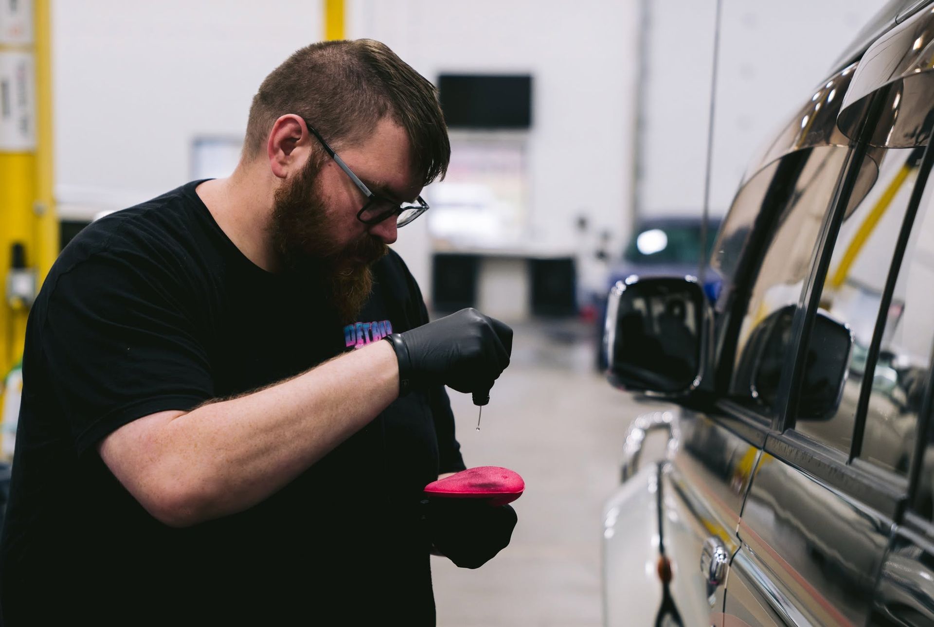 Professional ceramic coating application on vehicle in shop