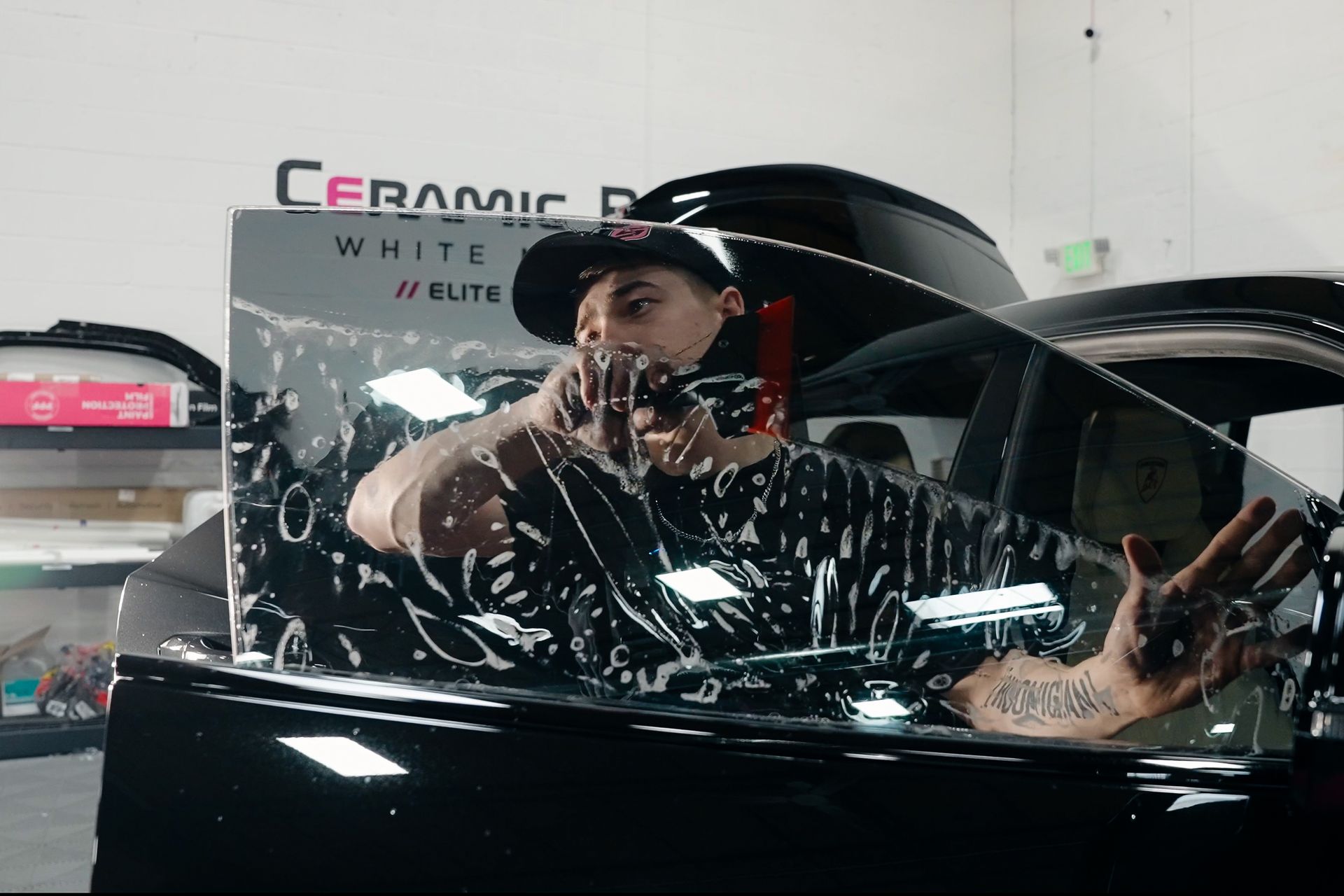 A man is wrapping a car window with ceramic film.