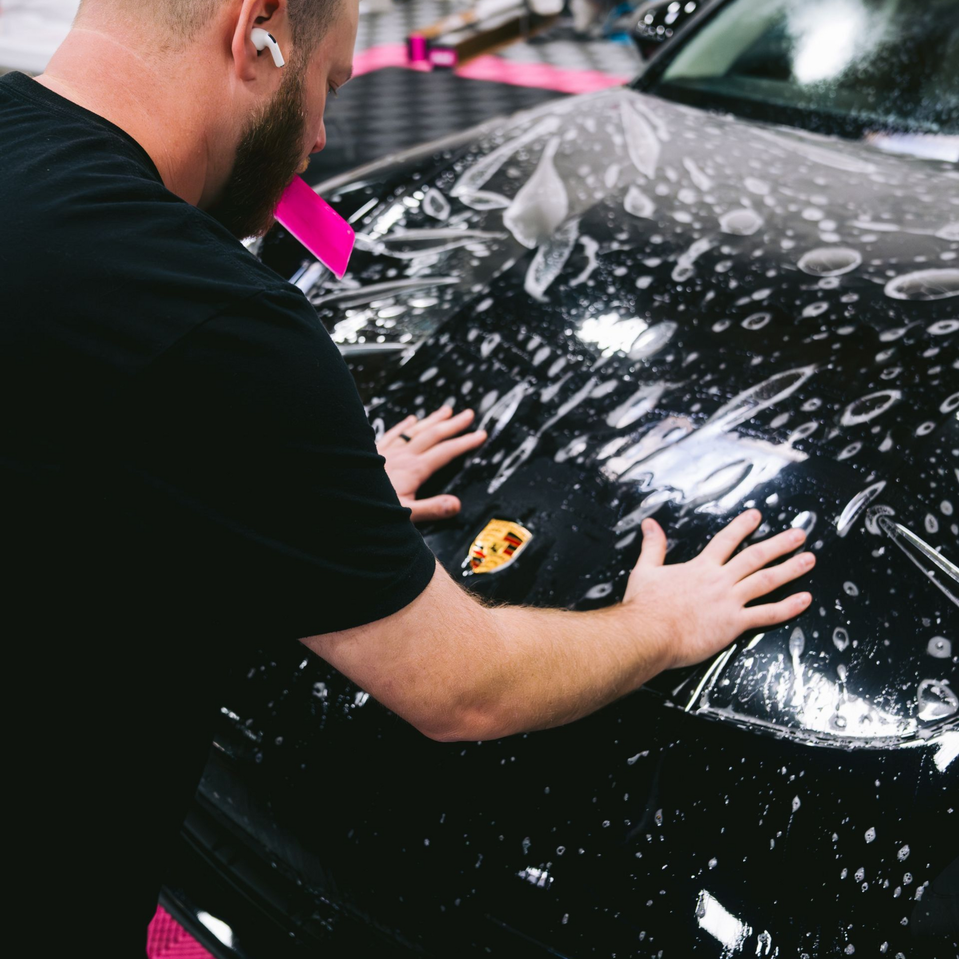 a man installing a ppf on a black car