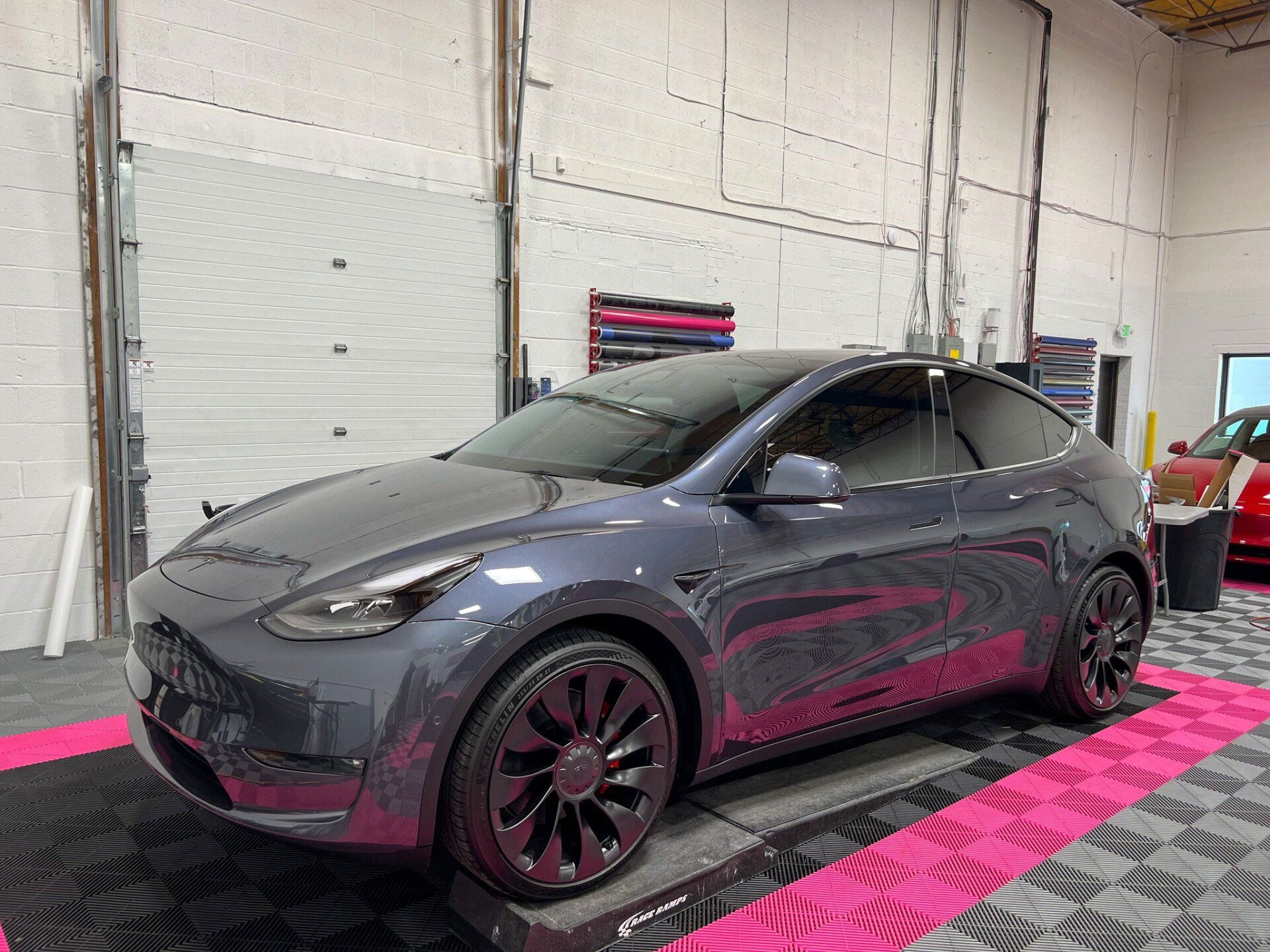 A tesla model y is parked in a garage.