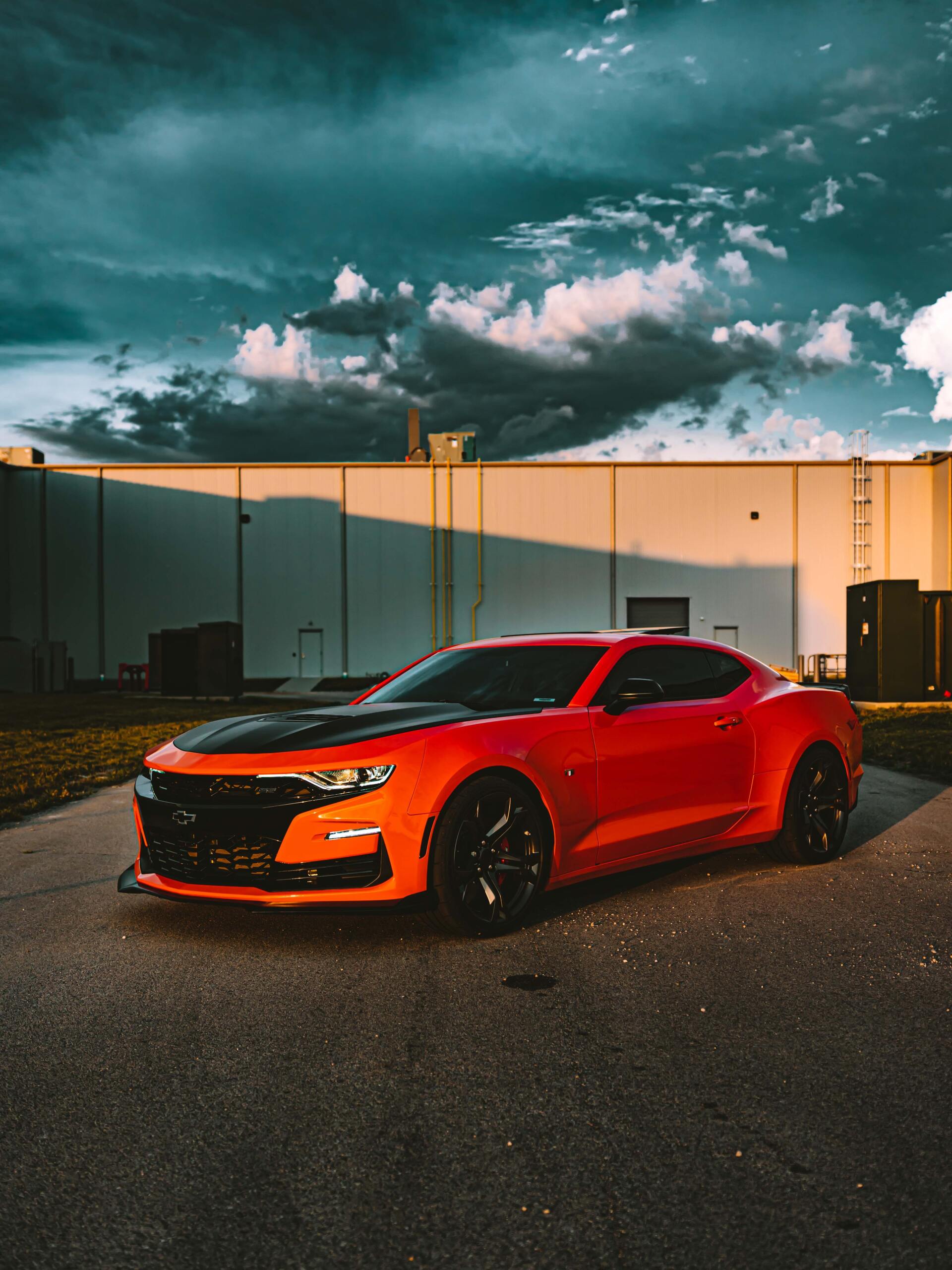 A red sports car is parked in front of a building