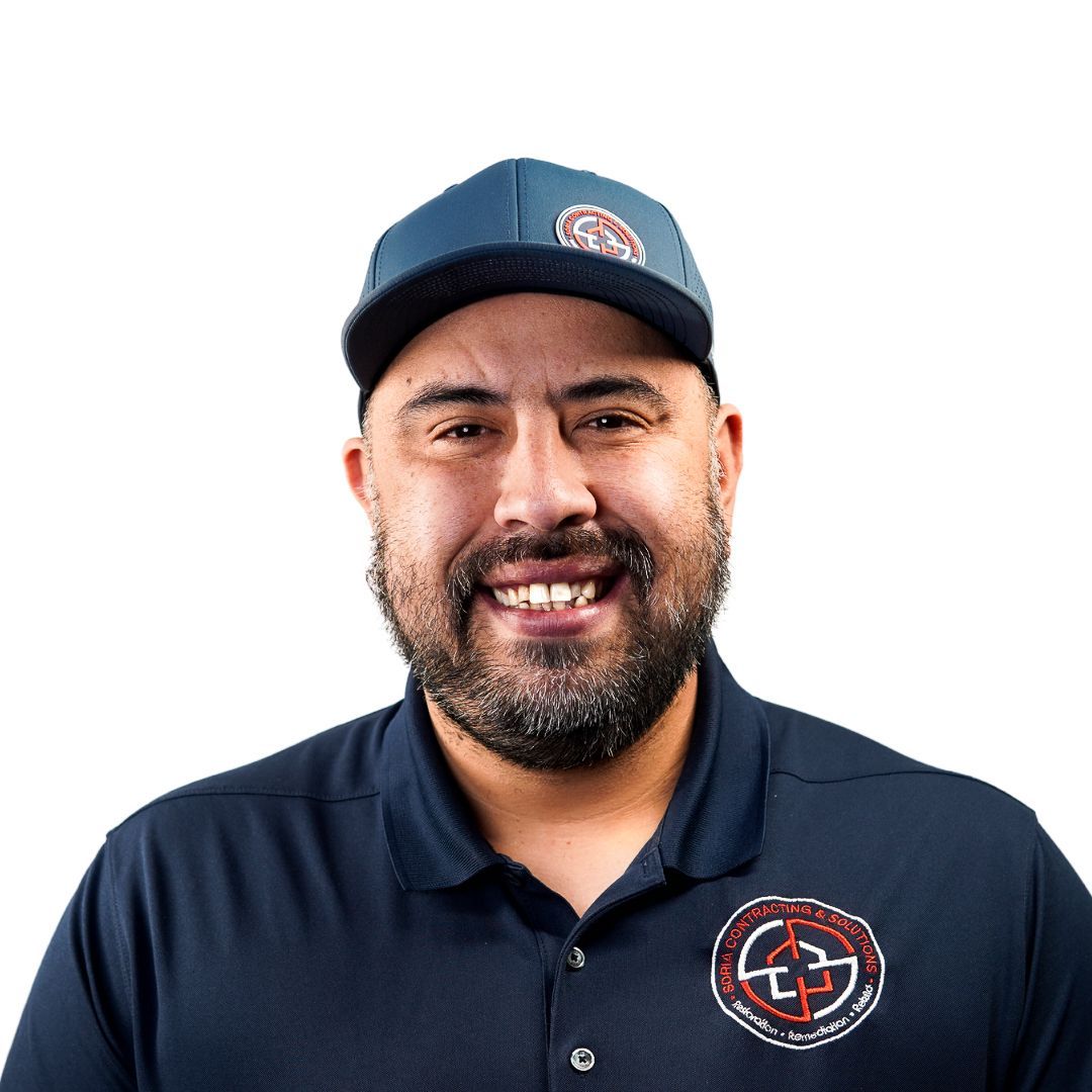a man with a beard is standing next to a truck holding a black jacket .