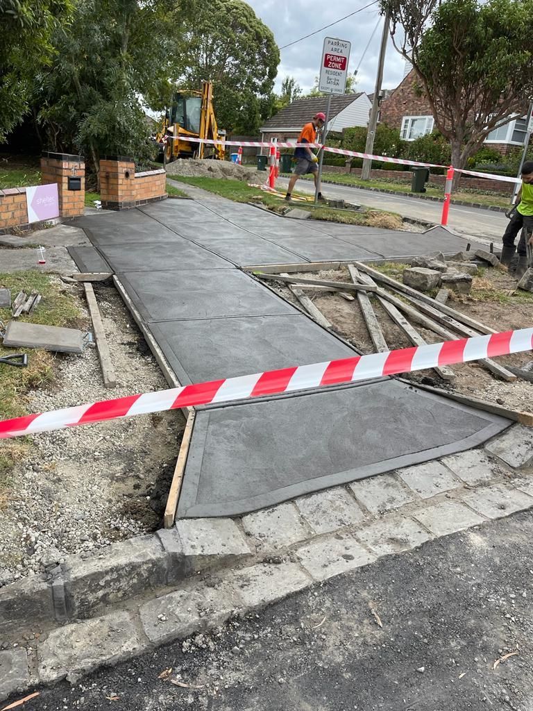 A concrete walkway is being built on the side of the road.