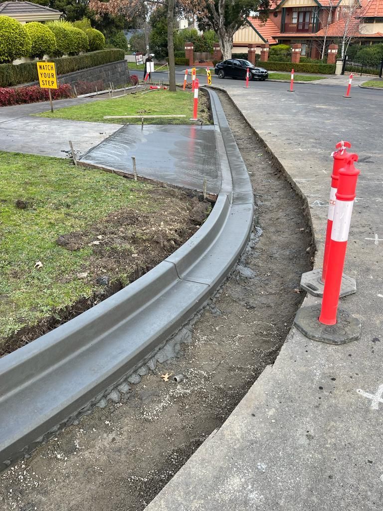 A concrete curb is being built on the side of a road.