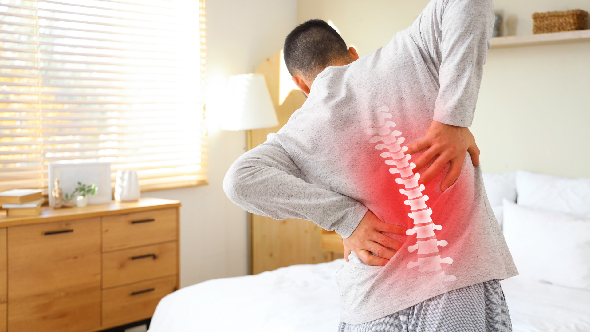 Person holding lower back with red pain overlay in a bedroom, suggesting back pain relief or injury