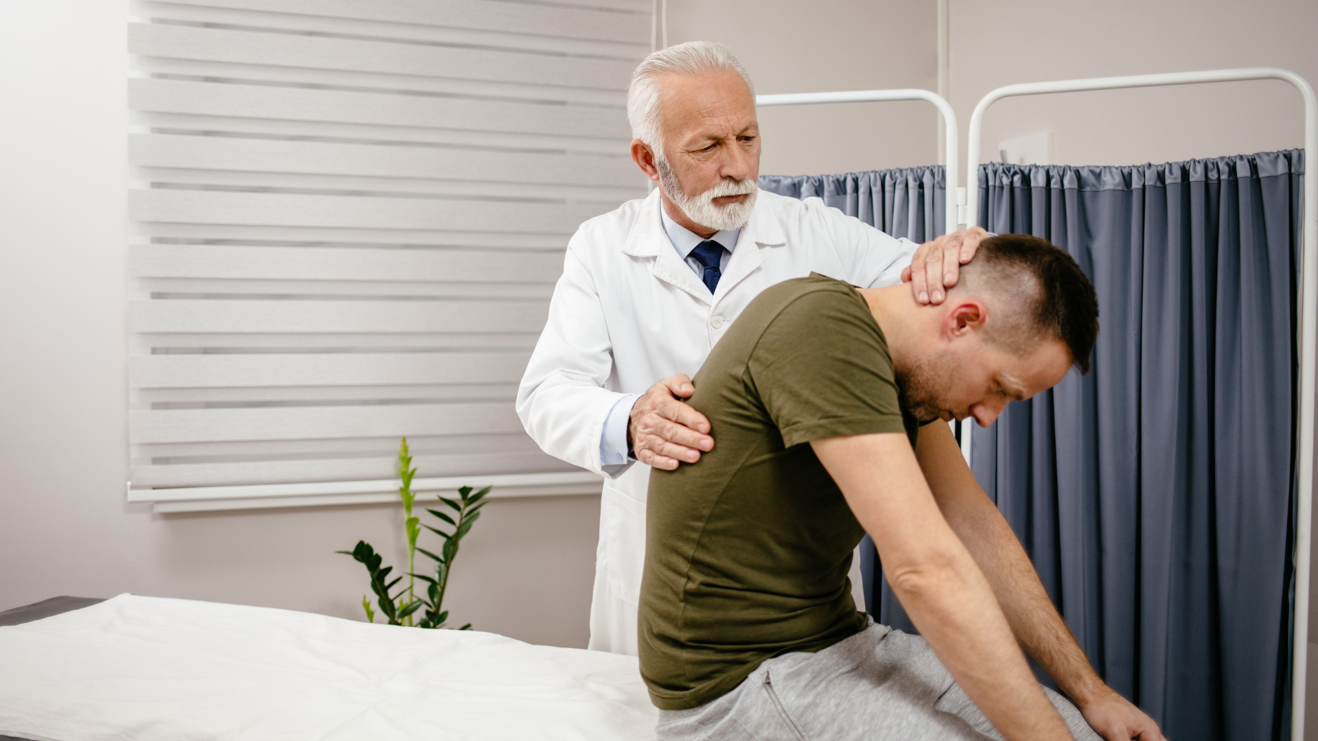 Doctor examining a patient's neck and back in an office setting.