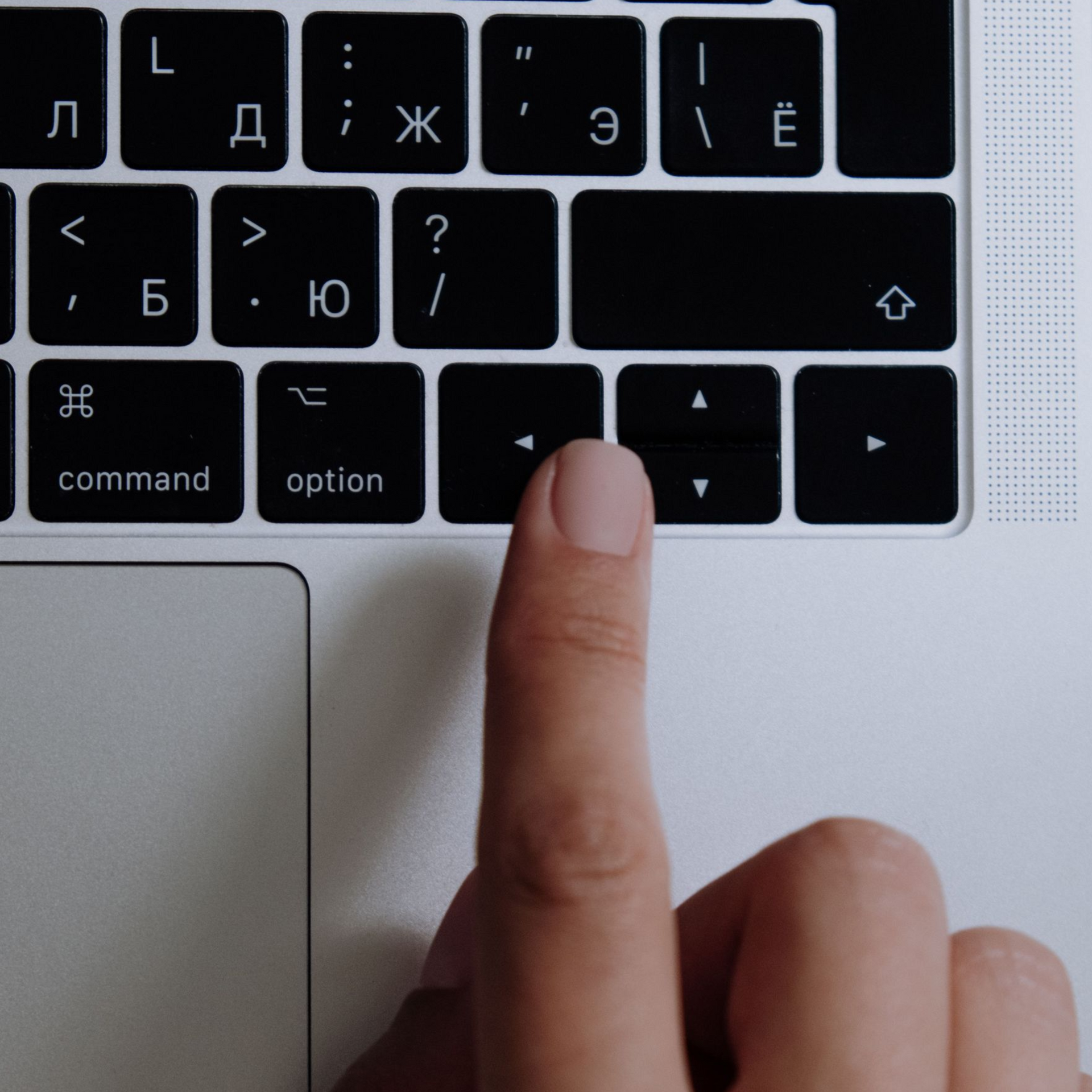 Finger pressing the Shift key on a black laptop keyboard