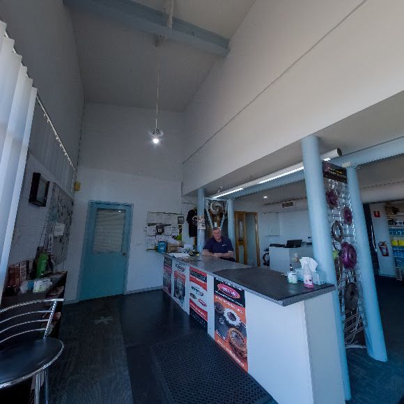 A Man Stands Behind a Counter in A Restaurant — Canberra Brake & Clutch Service In ACT, 2609