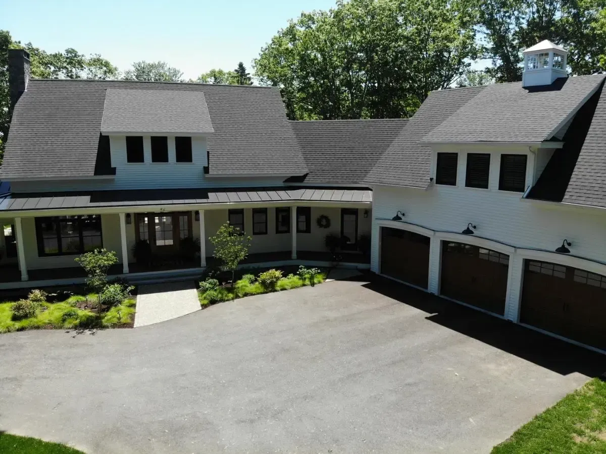 An aerial view of a large white house with three garages