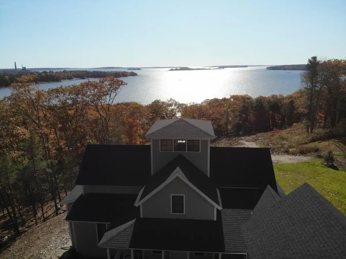 An aerial view of a house with a lake in the background