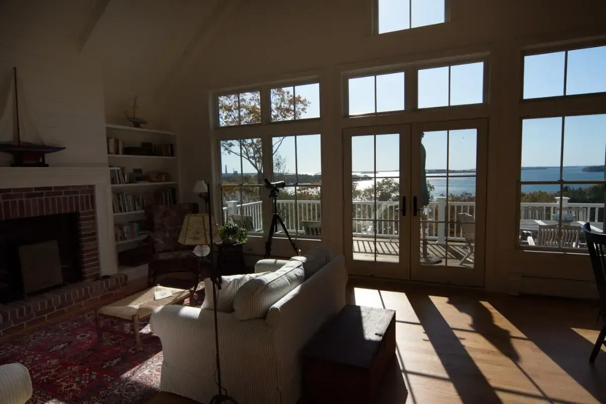 A living room with a lot of windows and a view of the ocean