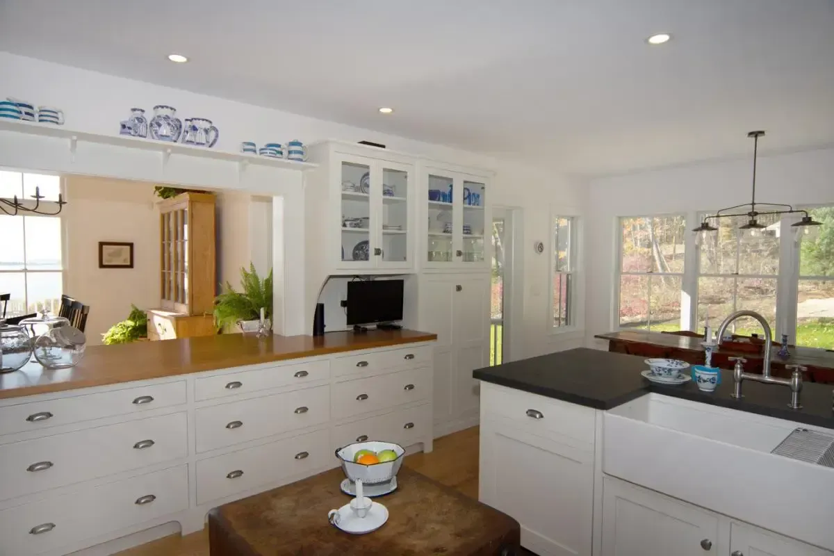 A kitchen with white cabinets and a black counter top
