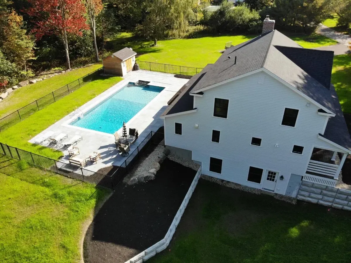 An aerial view of a house with a large pool in the backyard