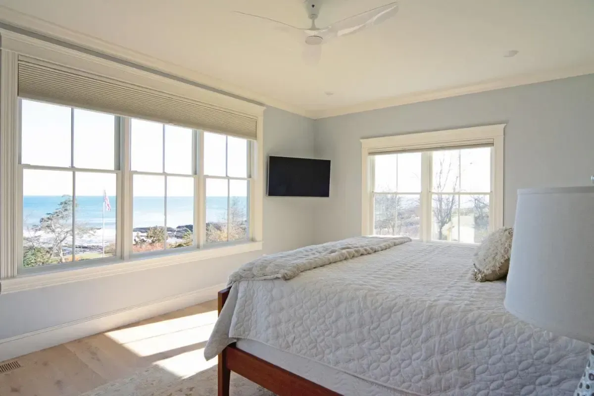 A bedroom with a king size bed , a television , and a view of the ocean.